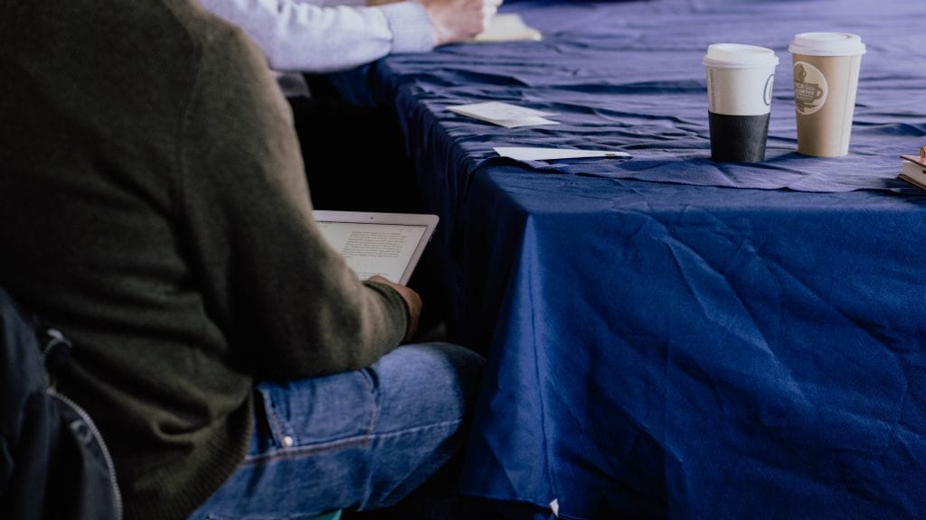 An over the shoulder shot of a person reading from a tablet.