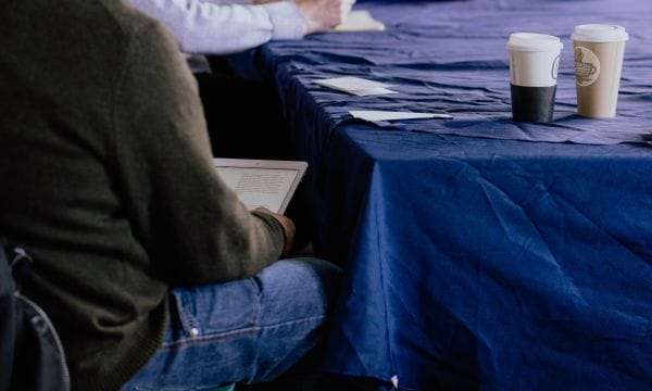 An over the shoulder shot of a person reading from a tablet.