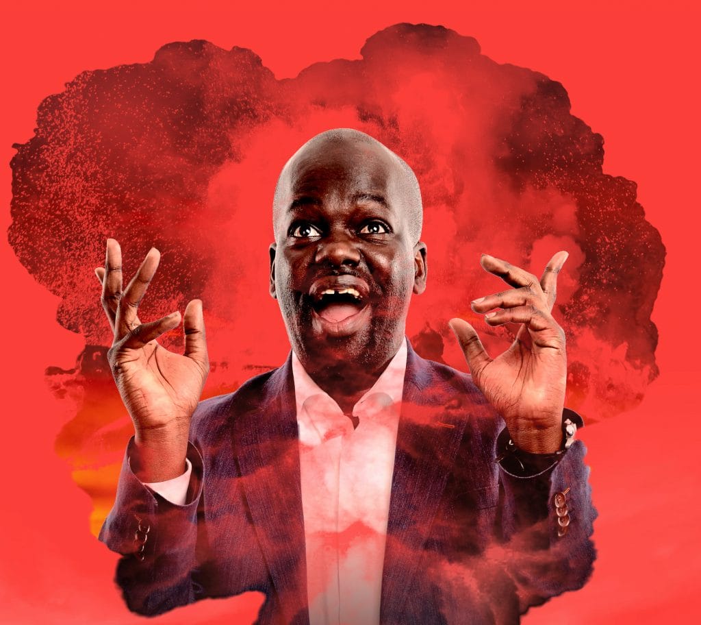 Daliso Chaponda stands in a mushroom cloud on a red background, he's pulling a silly face