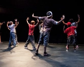 A group of young people practcising street dance on stage