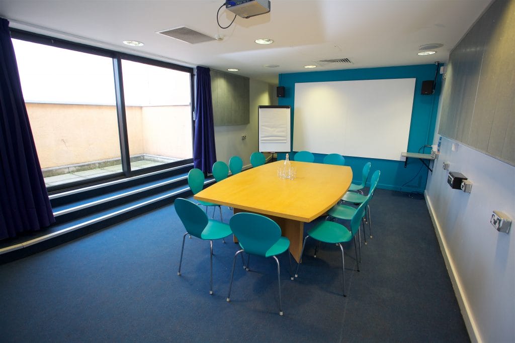 Meeting room with a large boardroom table surrounded by chairs