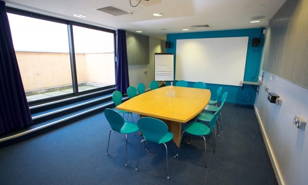 Meeting room with a large boardroom table surrounded by chairs