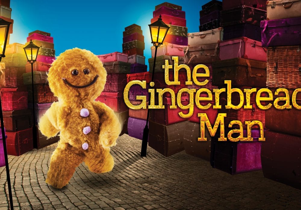 A fluffy, cartoon gingerbread man runs down a cobbled, lamplit street. Text on the right saying "The Gingerbread Man".