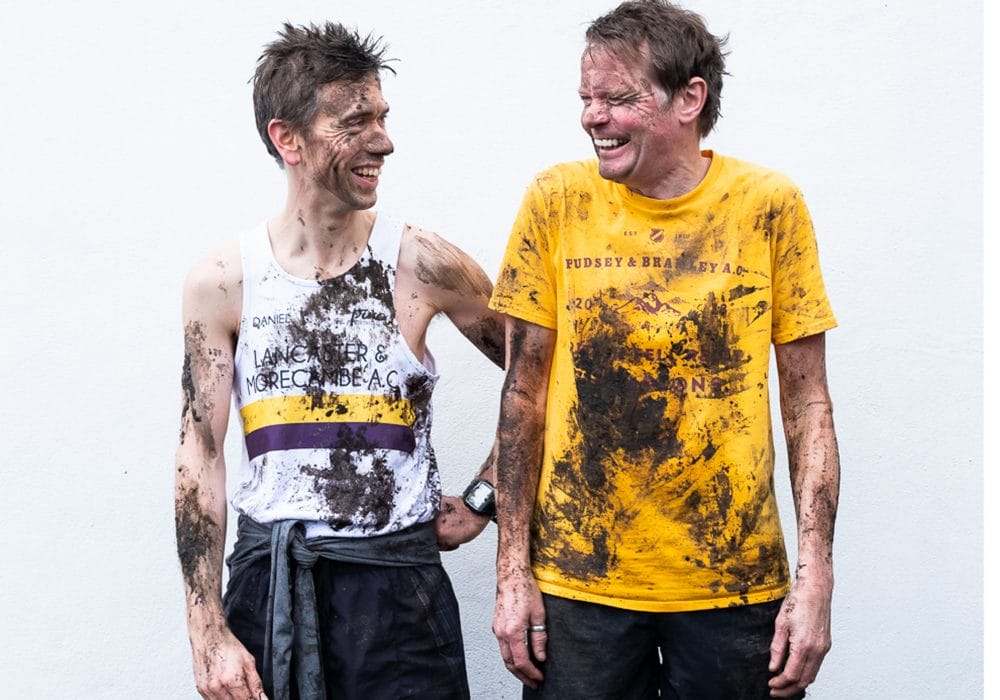 Daniel Bye and Boff Whalley in running attire. They are laughing and covered in mud.