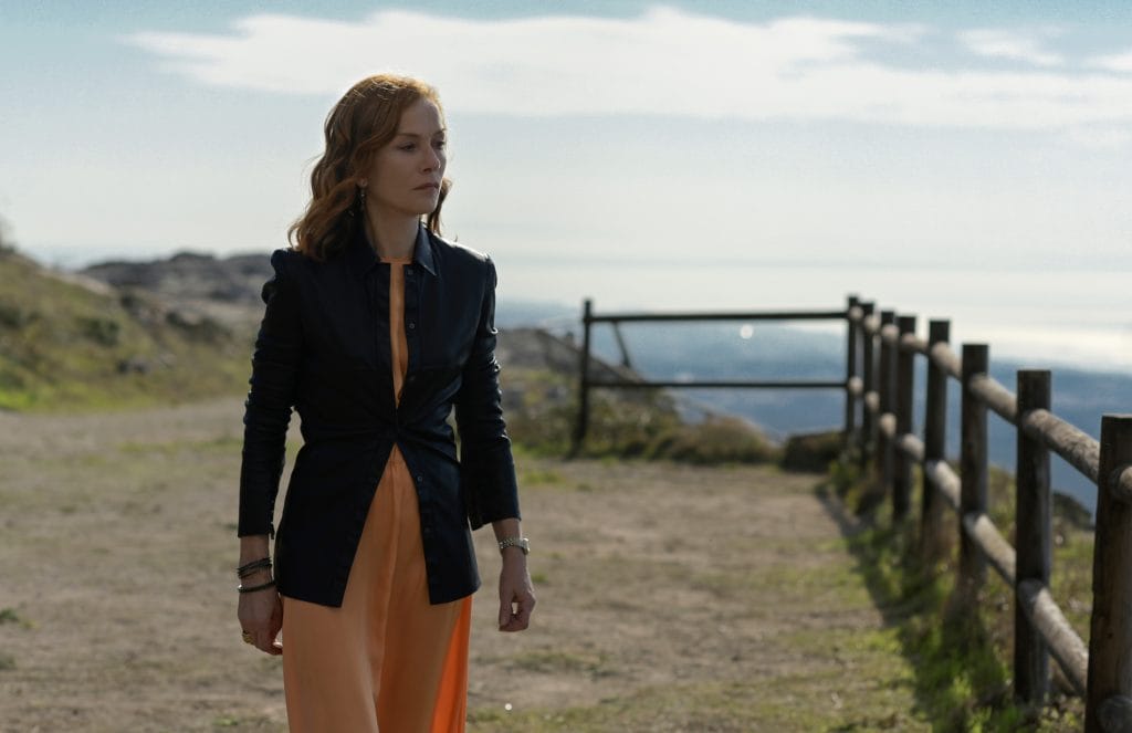 Woman stood on a dirt path near cliffs