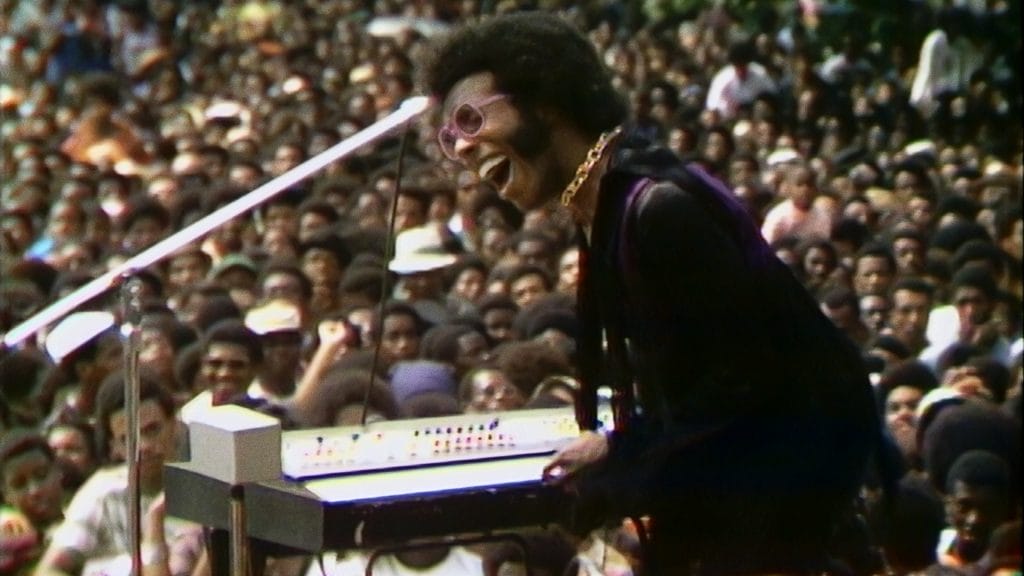 a man playing the piano on stage in front of a crowd