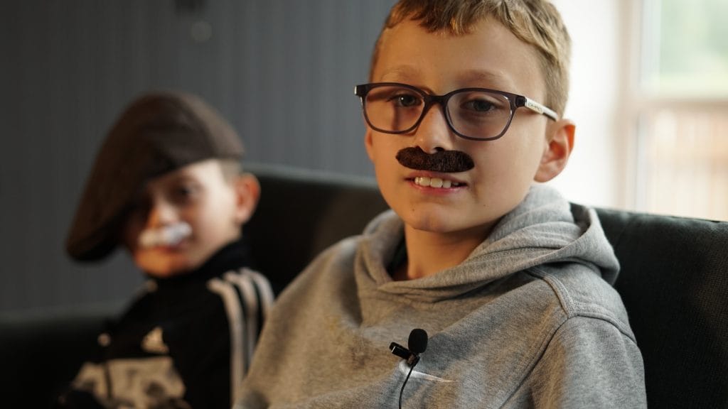 Two primary school age boys wearing fake moustaches