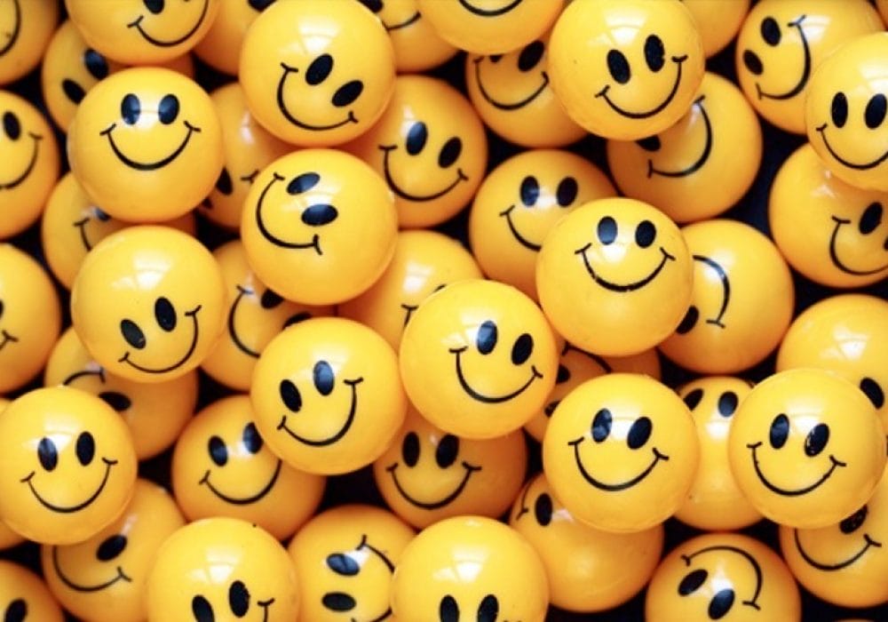 A pile of yellow plastic balls with 'smiley' faces