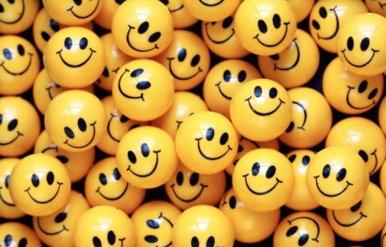 A pile of yellow plastic balls with 'smiley' faces