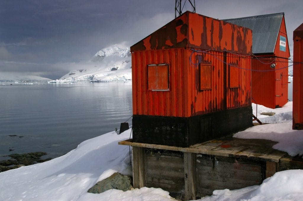 Red corrugated buildings in a snowy, icy landscape