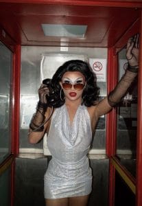 Portrait shot of artist Monarchy inside a telephone box