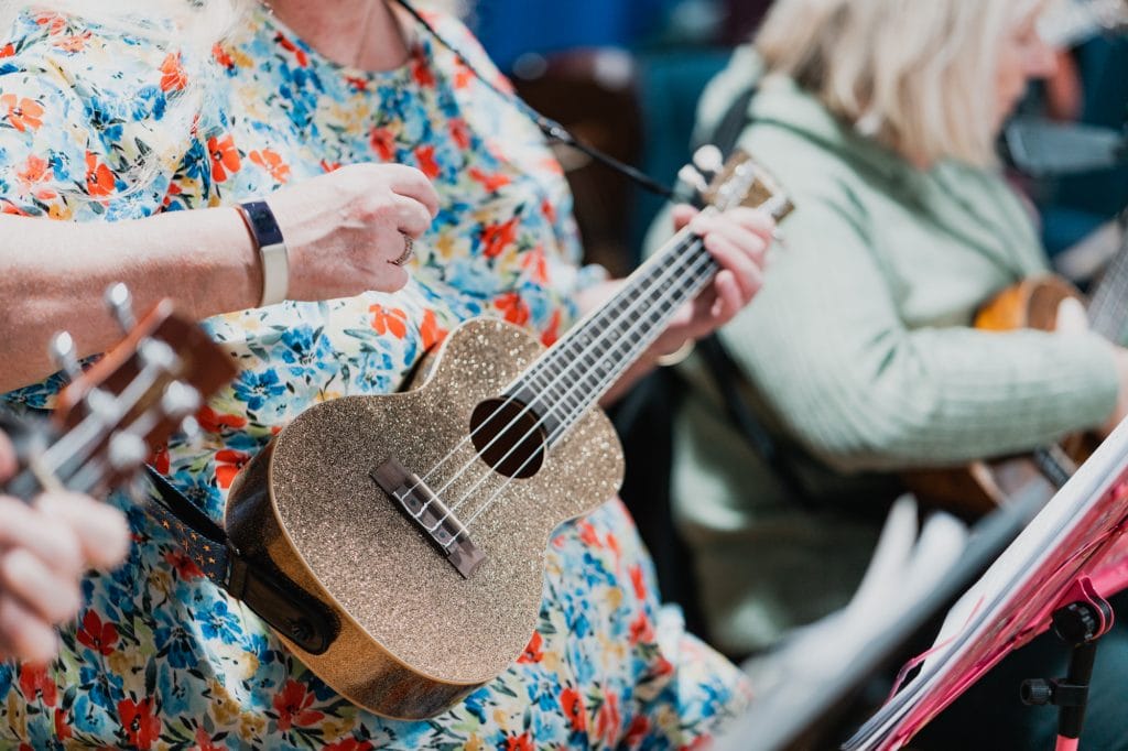 A close-up of a gold, glittery ukulele.