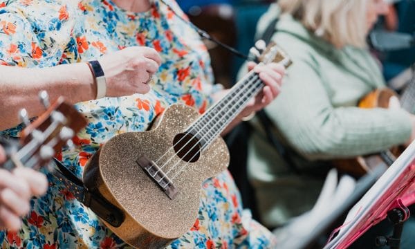 A close-up of a gold, glittery ukulele.