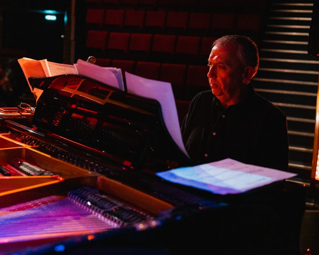 Jeremy from Pocket Jazz Orchestra playing piano on stage