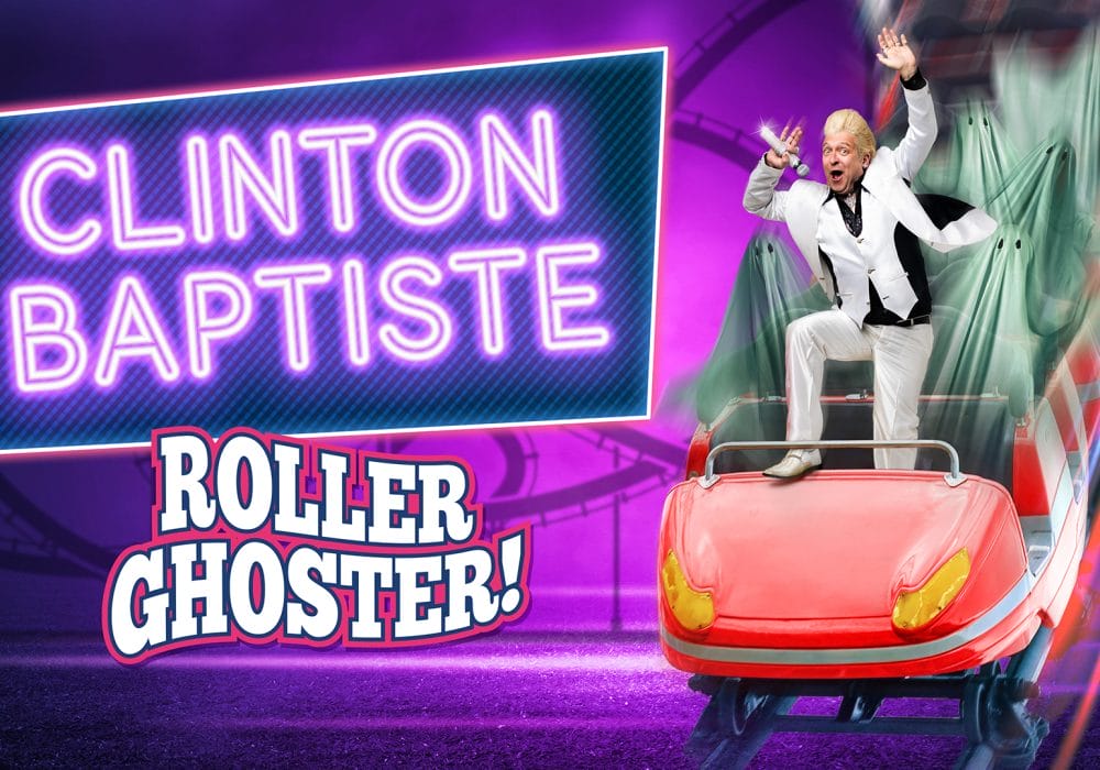 Comedian Clinton Baptiste stands atop a red roller coaster car, full of cloaked ghosts. He is holding a mic with one hand, and has his other hand high in the air. One of his legs is up on the front of the car.