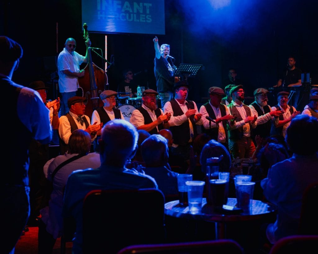 Mike McGrother and Infant Hercules male choir on stage