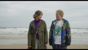 two people on a beach looking at each other