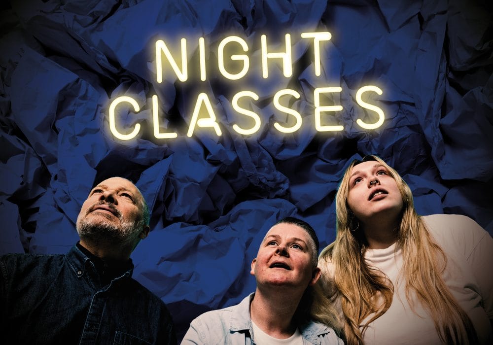 Three people looking upwards at a neon sign saying NIGHT CLASSES