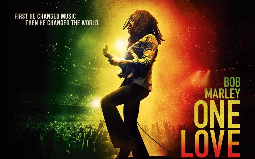 Bob Marley, lit up with green, yellow and red performing.