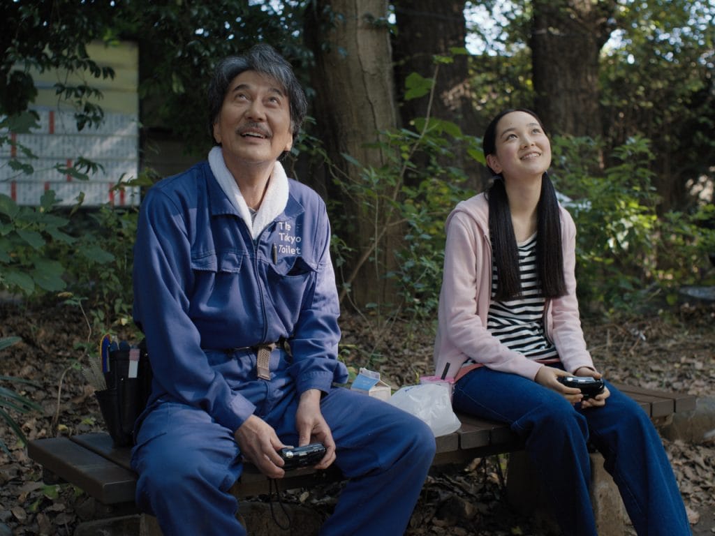 An elderly man and young girl gaze up at the sky.