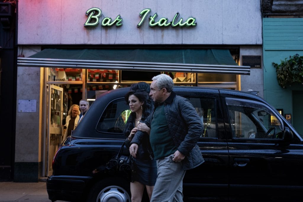 Amy walks arm in arm with her father, looking worried and tired.