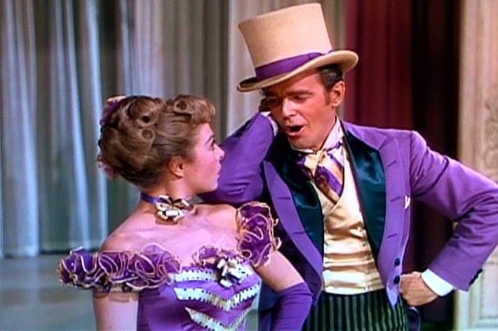 two performers dressed in purple in discussion