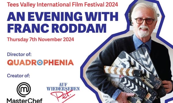 Image of an older white male with white hair and a white moustache. He has rounded black glasses wearing a blue shirt and grey cardigan. He is holding various film clapper boards with the text Quadrophenia. White background with blue and red text.