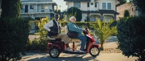 Thelma and her friend on a double seat scooter.