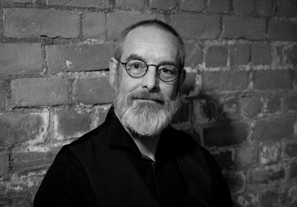 A black and white headshot of Dr Bob Beagrie, a white man, with shortly cropped hair and a grey beard.