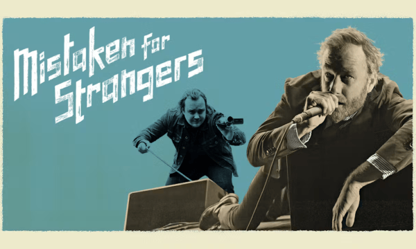 The singer Matt Berninger lounges to the right of the image, holding a microphone to his mouth. Behind him, the filmmaker Tom Berninger holds a handheld video camera. To the left of both men are the words Mistaken for Strangers.