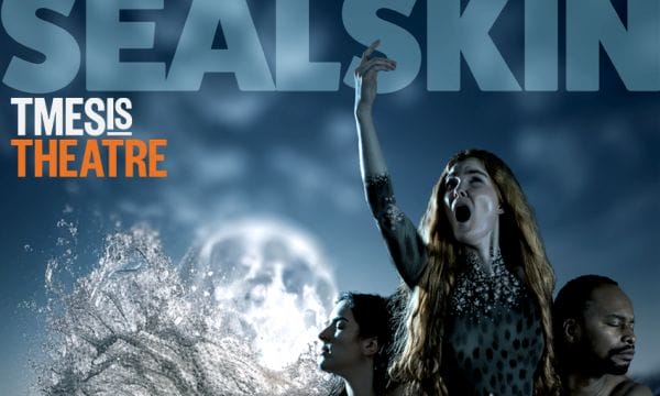 A stormy sea backdrop, a woman holds her arm up to the sky, her mouth is open. Two dancers are at her sides, they both have their eyes closed and are looking away. Text at the top of the image reads SealSkin Tmesis Theatre.