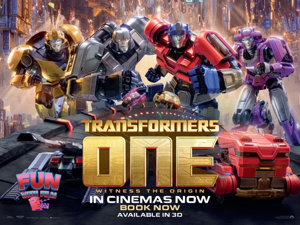 Four colourful Transformers robots are in the centre of the image, behind them is a futuristic cityscape. In front of them in metallic gold lettering are the words Transformers One: Witness the origin.