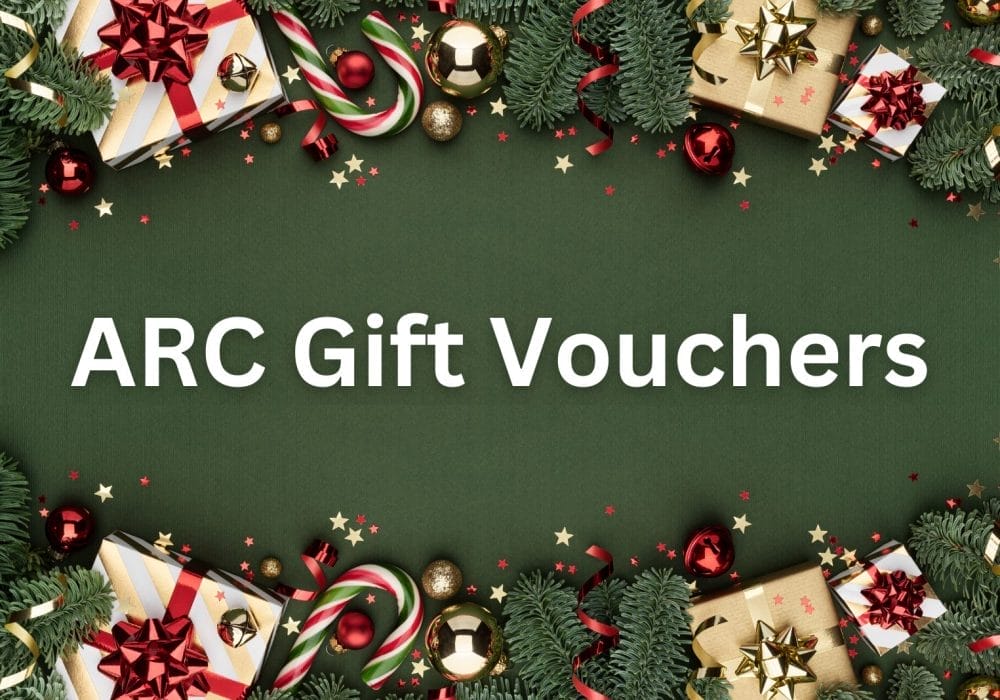 A scattering of gift wrapped Christmas presents, candy canes, and confetti on a dark green background. White text reads ARC Gift Vouchers