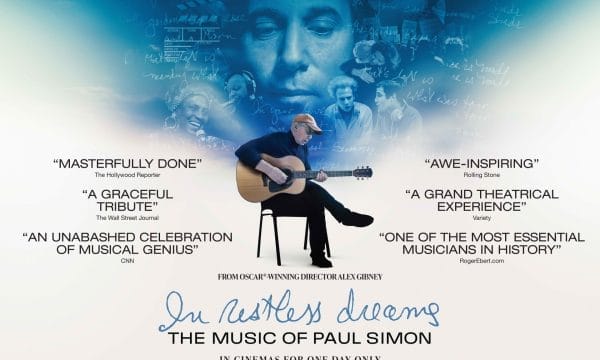 In Restless Dreams Paul Simon Sat crossed legged on a chair playing a guitar