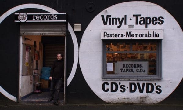 Sound It Out records shop front with owner stood on the step opening to the shop.