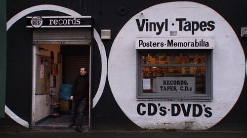 Sound It Out records shop front with owner stood on the step opening to the shop.