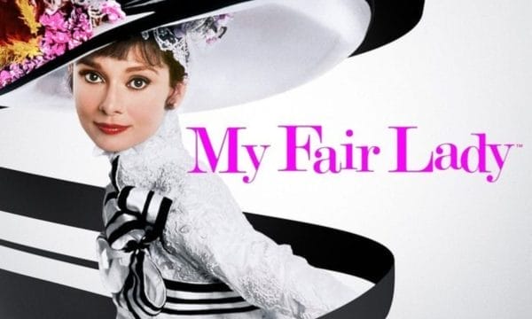 Actress Audrey Hepburn, wearing a large black and white hat. Pink text reads: My Fair Lady.