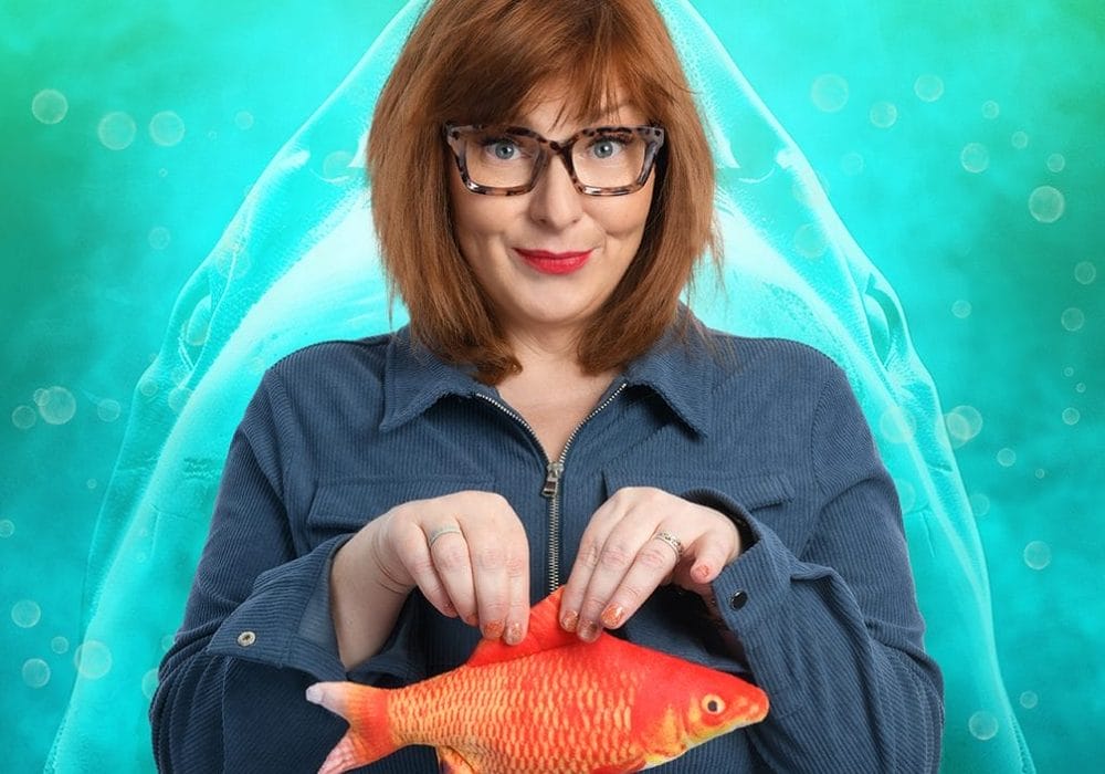 Nina holds a goldfish with a smile