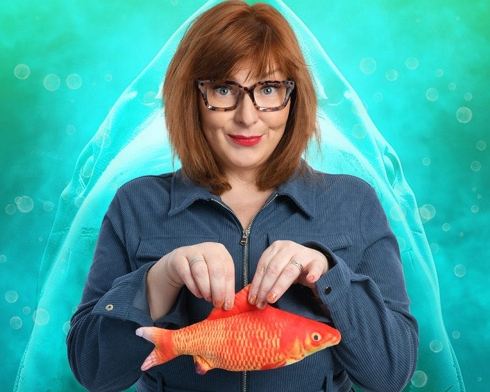 Nina holds a goldfish with a smile