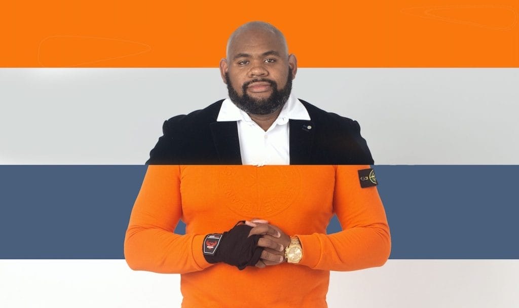 Performer Reece Williams, a Black man with a short, dark beard. The image is split into two segments. The top segment shows Reece wearing a suit jacket and white shirt, the bottom segment has him wearing an orange Stone Island jumper, a black glove, and a gold watch.