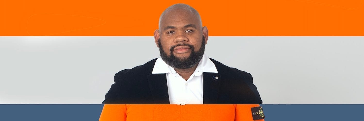 Performer Reece Williams, a Black man with a short, dark beard. The image is split into two segments. The top segment shows Reece wearing a suit jacket and white shirt, the bottom segment has him wearing an orange Stone Island jumper, a black glove, and a gold watch.