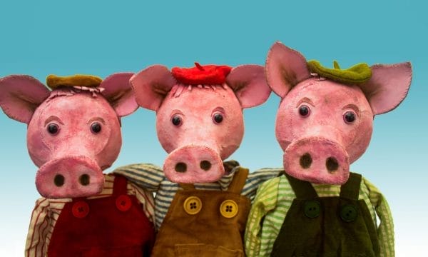 An image of three piglet puppets on a light blue background.