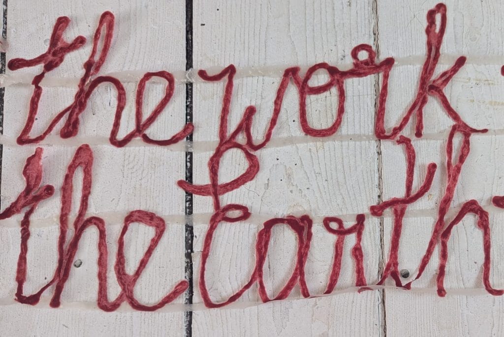 an image of red string that says 'the work the earth'