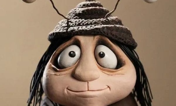A clay style animated character with large expressive eyes, a round body, and long black hair. The character is wearing a knitted hhat with two antennae, with eyeballs on the end of each, like a snail. the background is a plain beige colour.