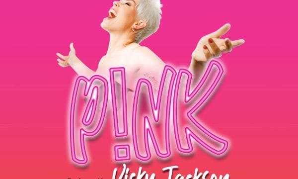 a promotional poster for a tribute show to the artist Pink. The poster features: A bright pink background The text "THE WORLD'S NO.1 TRIBUTE TO" at the top A large neon-style "P!NK" logo in the centre "Performed by Vicky Jackson" at the bottom The image shows a performer with short blonde/white hair in a pose reminiscent of Pink's energetic performance style, with arms outstretched against the vibrant pink backdrop.
