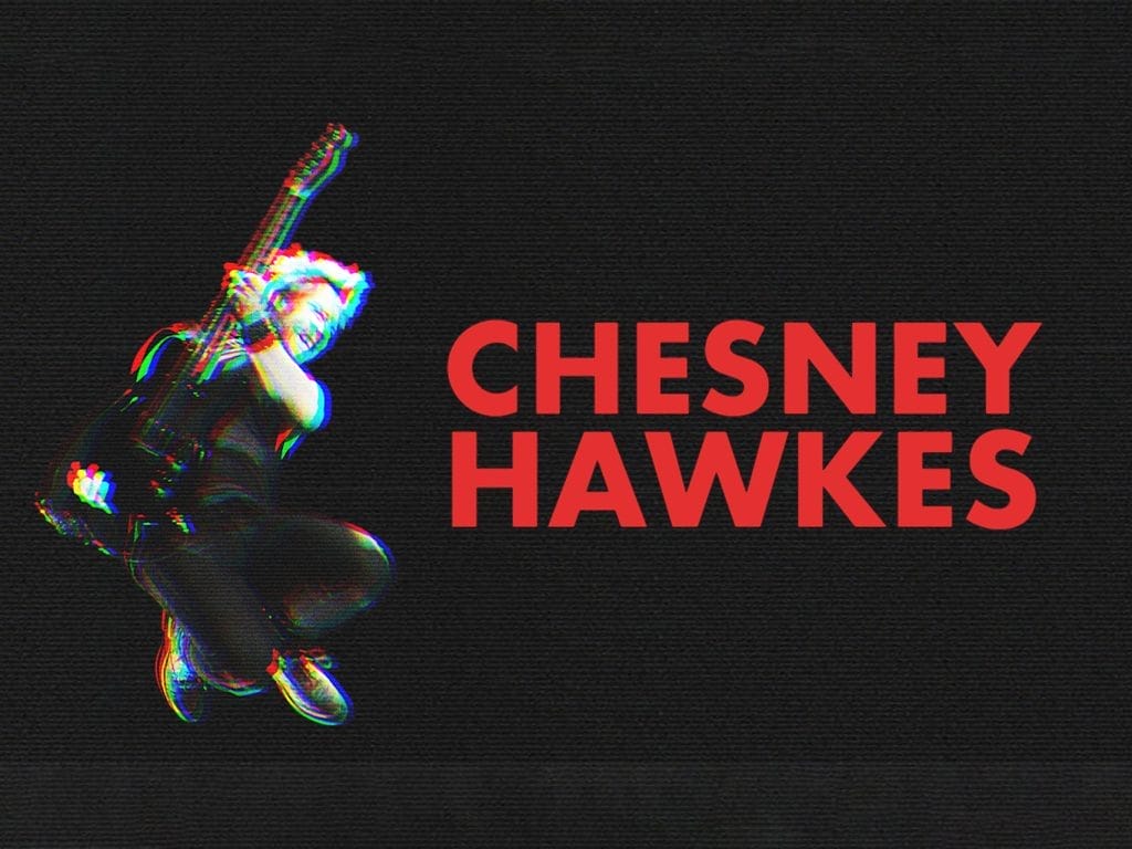 An image with red writing that reads 'Chesney Hawkes' to the left is a man mid-air holding a guitar. There is an glitch effect which makes the black and white image have blurred colours of red and blue surrounding it.