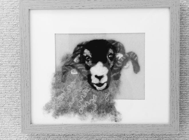 a black and white image of a needle felt ram in a frame