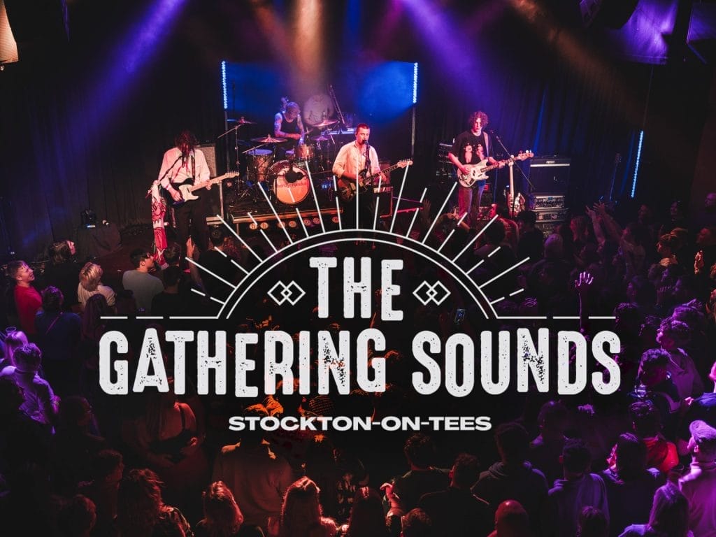 Live music venue photograph showing a band performing on stage with dramatic purple and blue stage lighting. The stage features a four-piece band with guitars, drums, and other instruments, with atmospheric smoke effects. In the foreground, a large crowd of audience members can be seen enjoying the performance, many with raised hands. Overlaid on the image is 'The Gathering Sounds' logo in large white distressed text with a decorative sunburst design above it, and 'Stockton-on-Tees' underneath. The scene captures the energetic atmosphere of a live music event in an intimate venue setting