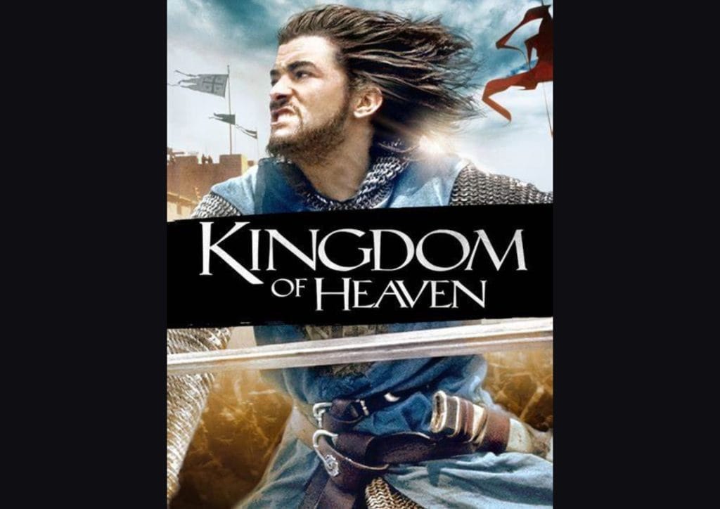 An image of a man with long hair and a beard wearing chain mail and holding a sword. In the background there is sky and flags waving. The text reads 'Kingdom of Heaven'