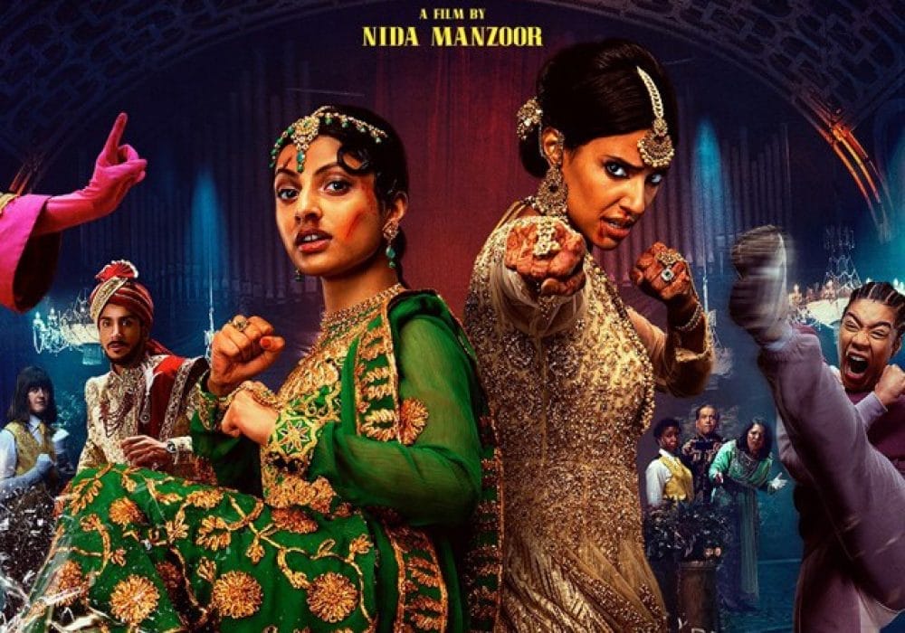 Vibrant, colourful imagery with what appears to be characters in elaborate costumes - some in traditional South Asian attire with ornate jewellery and embroidery, and others in more contemporary dress. The styling suggests this might be a comedy or musical film that blends traditional and modern elements.